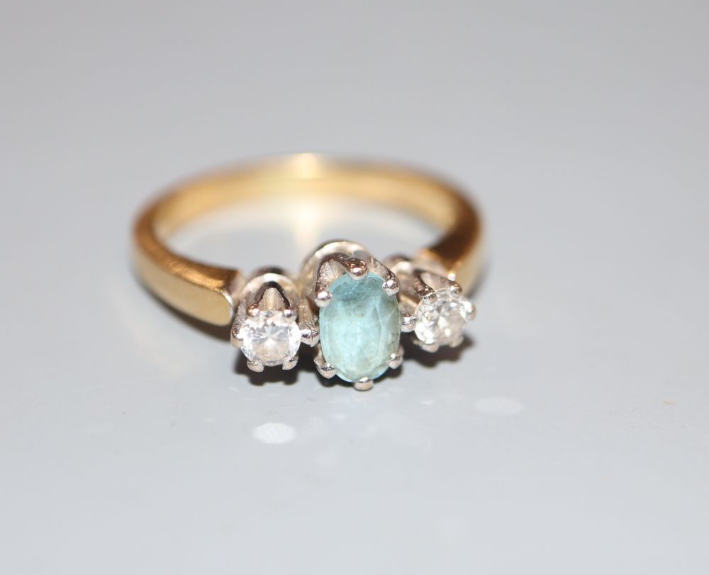 A modern 18ct gold, aquamarine and diamond three-stone ring, size M, gross 5 grams.